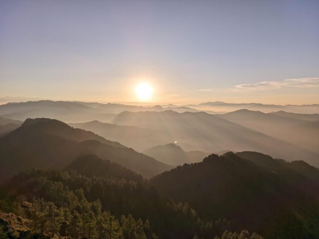 Panoramic sunrise view of pine forests and Himalayan valleys in Dalhousie, one of the best hill stations in Himachal Pradesh