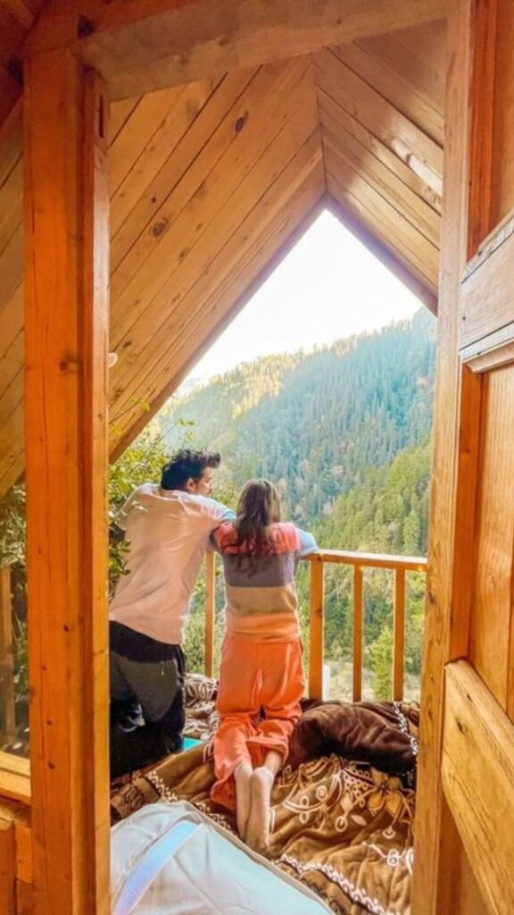 Couple enjoying a romantic mountain getaway in a wooden cabin surrounded by pine forests in Dalhousie