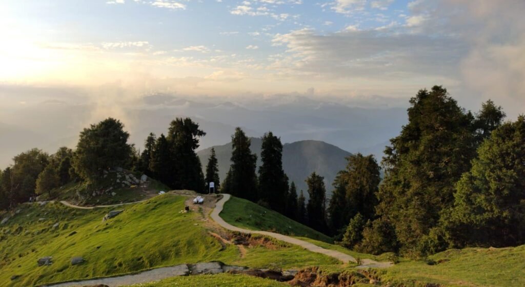 Trekkers enjoying the Dainkund Peak Trek in Chamba district with panoramic Himalayan views