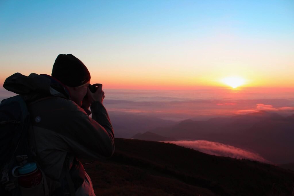 Photographer capturing a mountain sunrise in Dalhousie during the golden hour