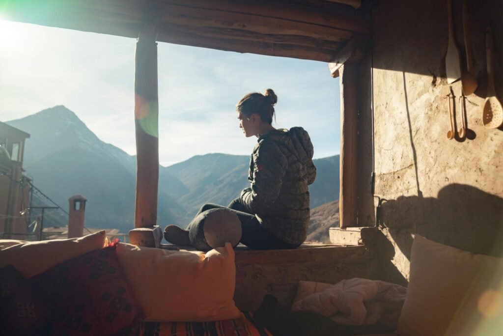 Traveller sitting quietly outdoors overlooking a Himalayan mountain landscape
